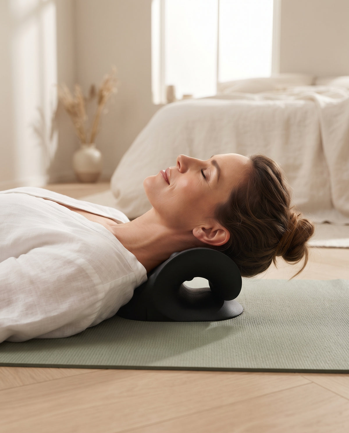Femme détendue, la nuque posée sur l’étireur cervical